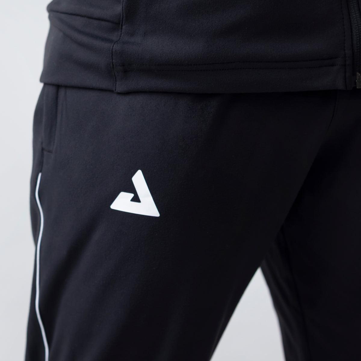 Schwarze Sporthose mit weißem Logo und seitlichem weißen Streifen, Nahaufnahme am Oberschenkel.